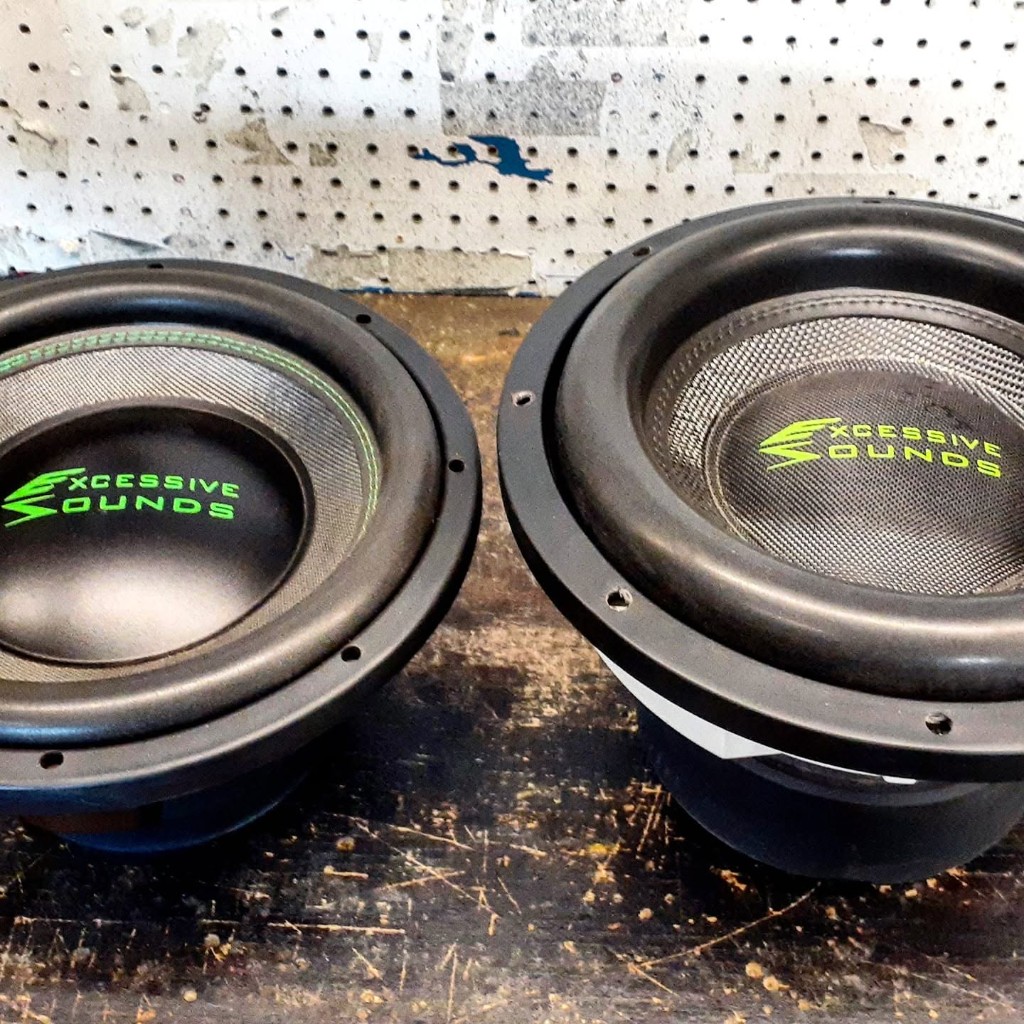 Two Excessive Sounds subwoofers on a worn shop bench