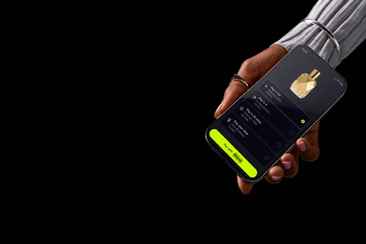 A phone in hand showing Klarna pay-in-full, pay in 4, pay in 30 days, and pay over time
